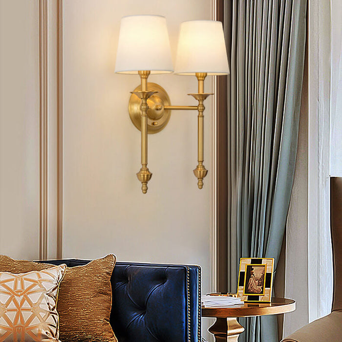 Single-head brass sconce lit in a living room