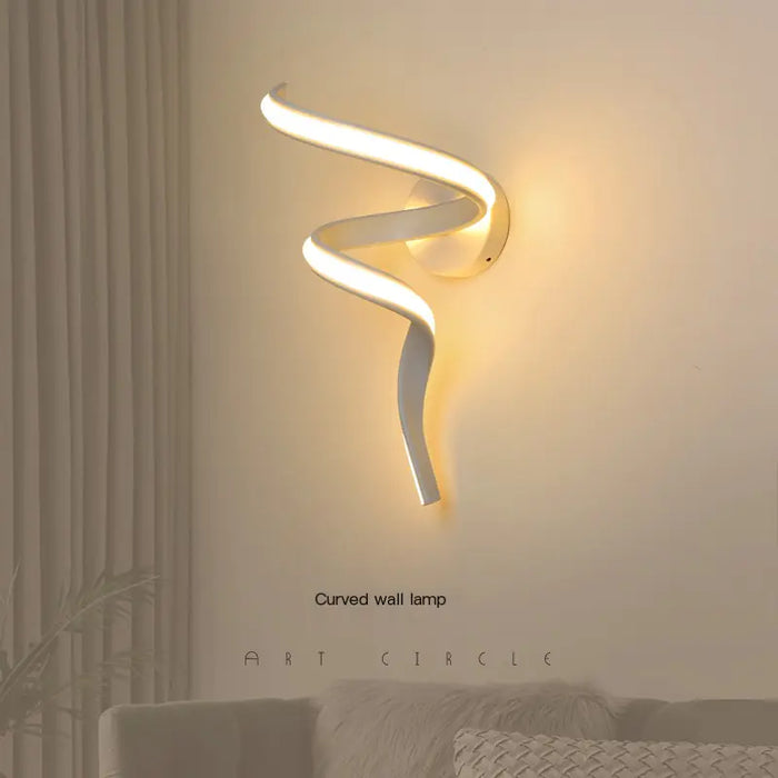 Curved ribbon LED wall light lit on a bedroom wall
