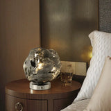 Glass lava rock lamp lit on a bedside table