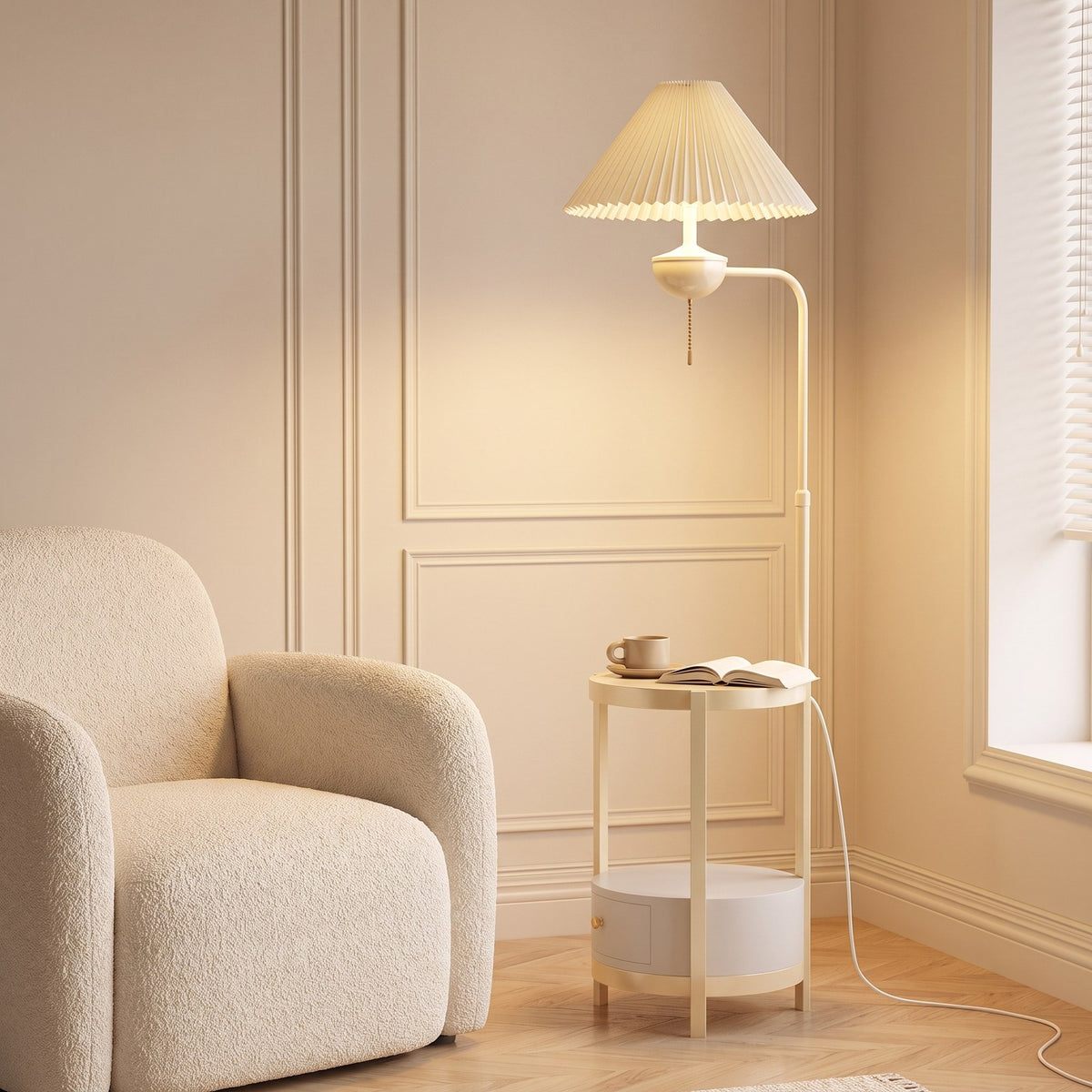 Cream floor lamp with pleated shade and built-in round side table beside a boucle armchair