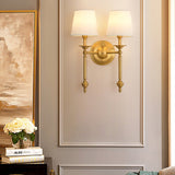 Two-arm brass wall light with white fabric shades
