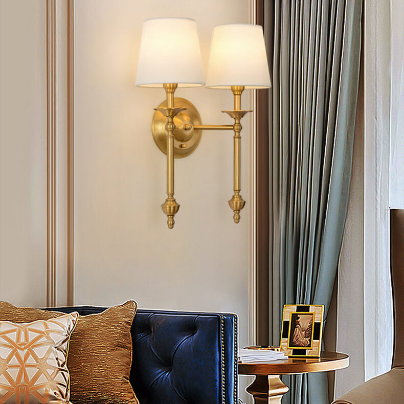 Single-head brass sconce lit in a living room