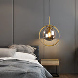 Glass globe pendant hung beside a bed