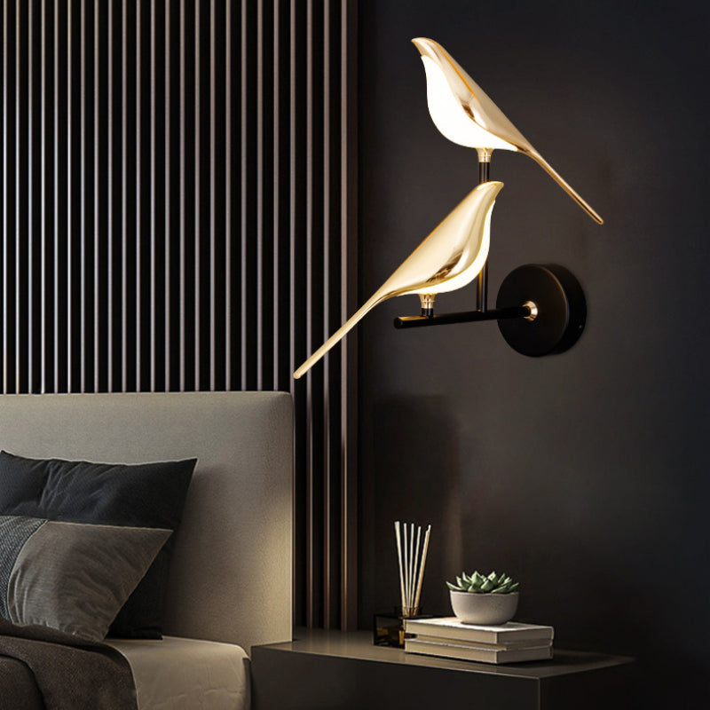 Gold bird wall light above a bed
