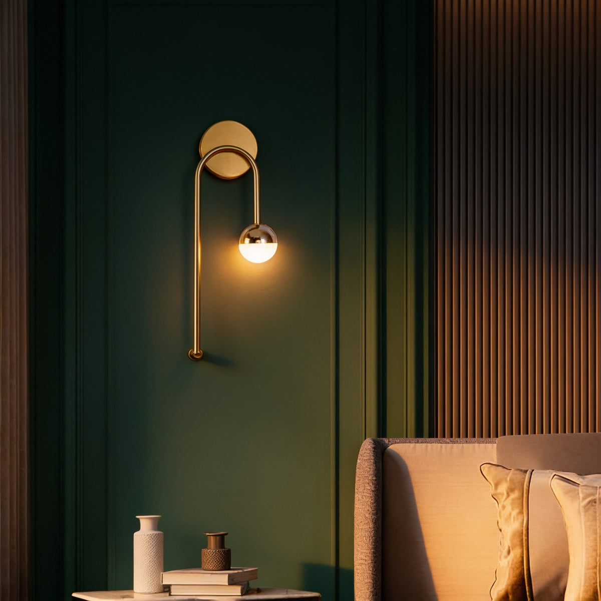 Brass ring and glass globe wall sconce on a dark green panelled wall