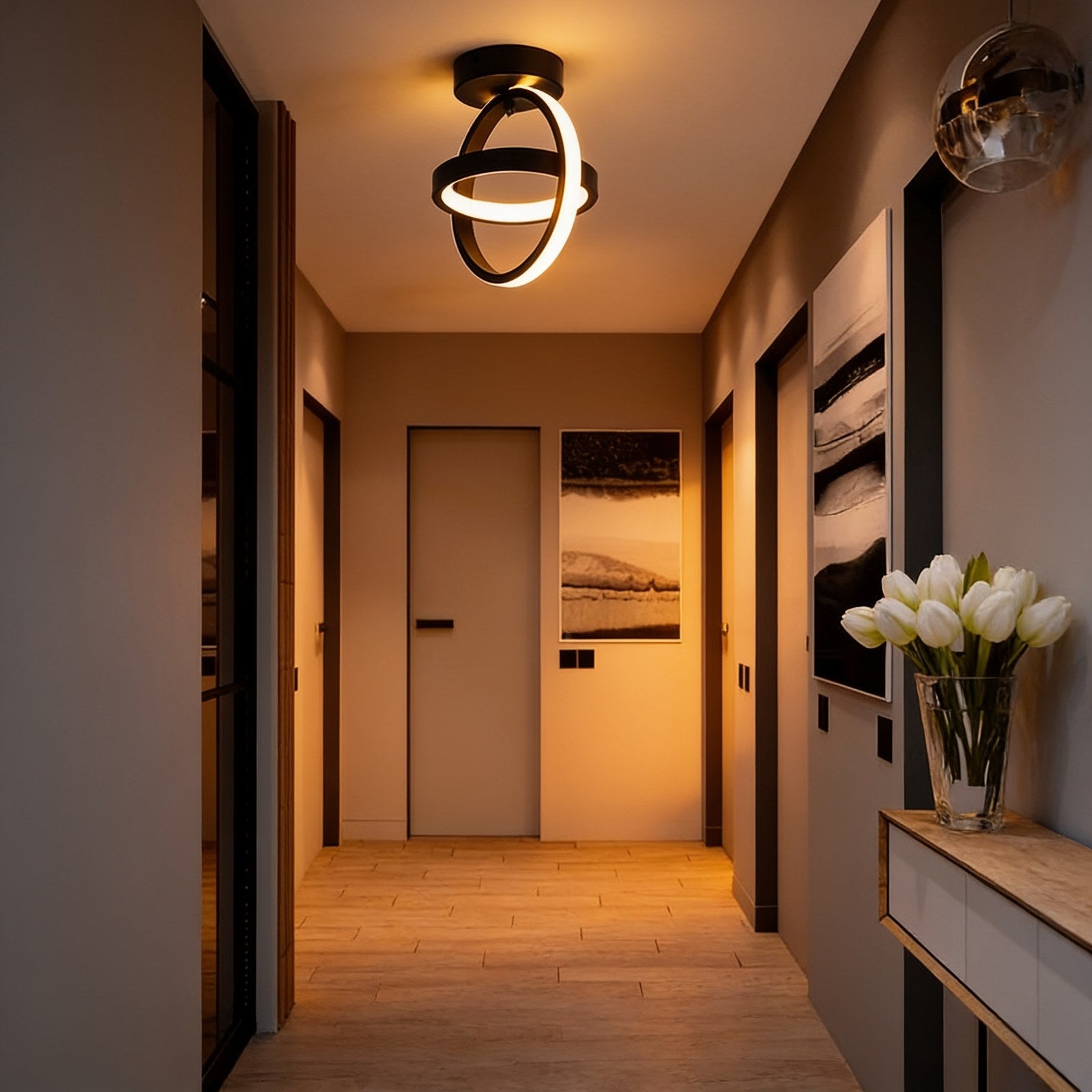 Black interlocking rings LED ceiling light in a hallway above a console