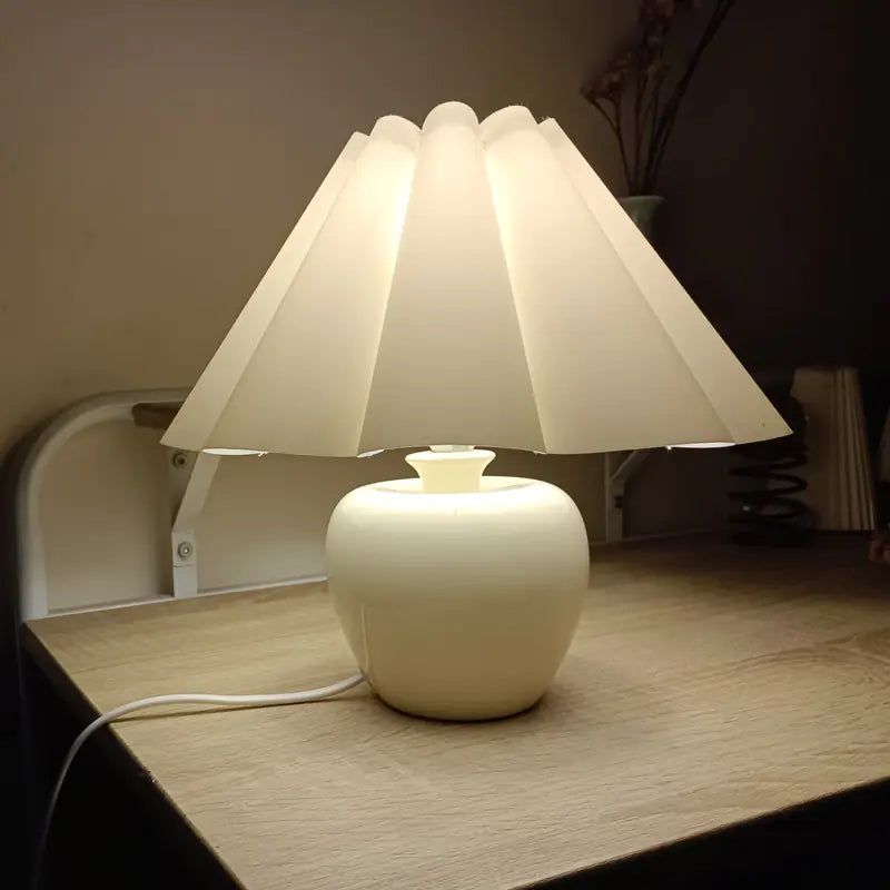 Ceramic apple base table lamp beside a bed