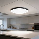 Ultra-thin round LED ceiling panel with black rim above a kitchen worktop