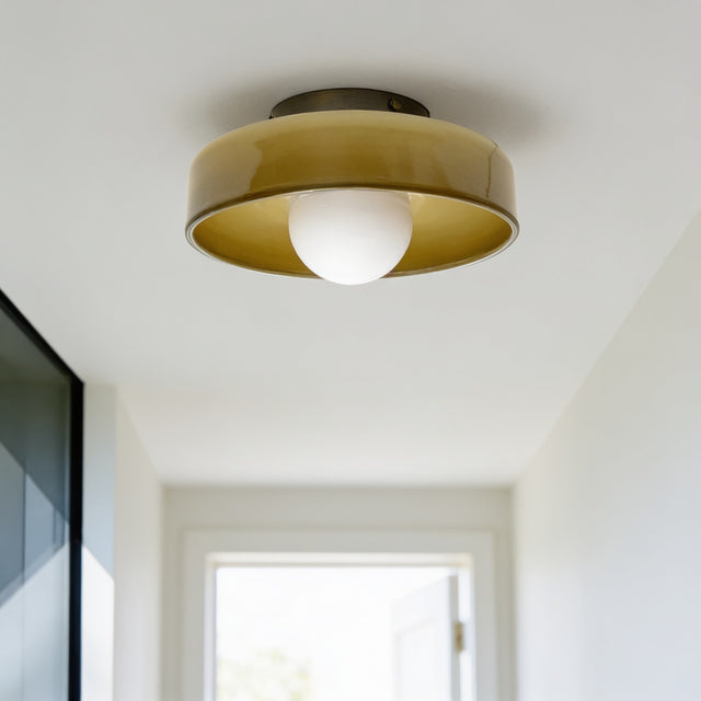 Brass and amber glass flush mount ceiling light in a bright hallway