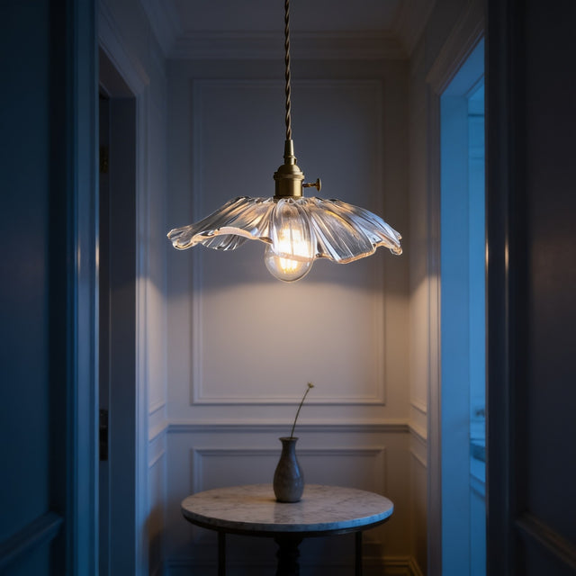 Brass pendant light with ribbed glass flower shade above a marble hallway table