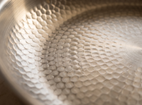 Macro of the hammered fish-scale titanium cooking surface