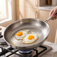 Titanium pan with eggs sliding on the hammered surface