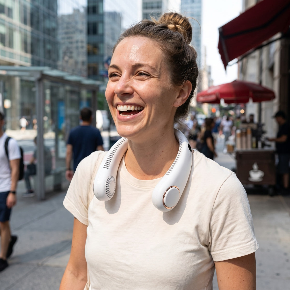 Woman laughing on a hot city street wearing the bladeless neck fan