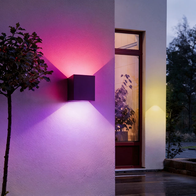 Smart RGB outdoor wall light casting magenta and violet cones beside a front door