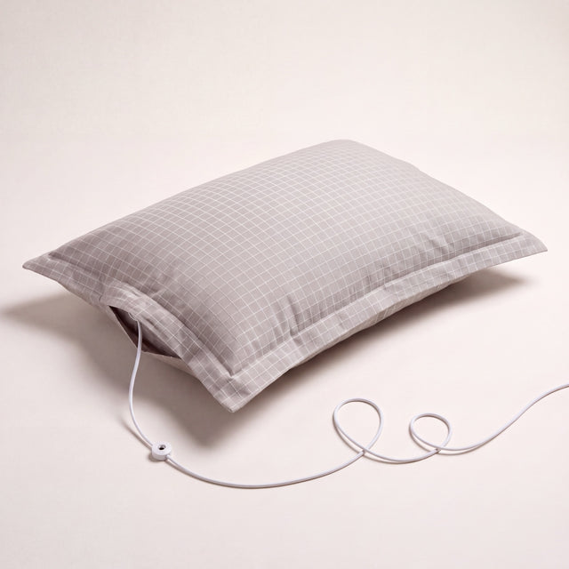 The Nostra Grounding Pillowcase, studio shot, with its grounding cord