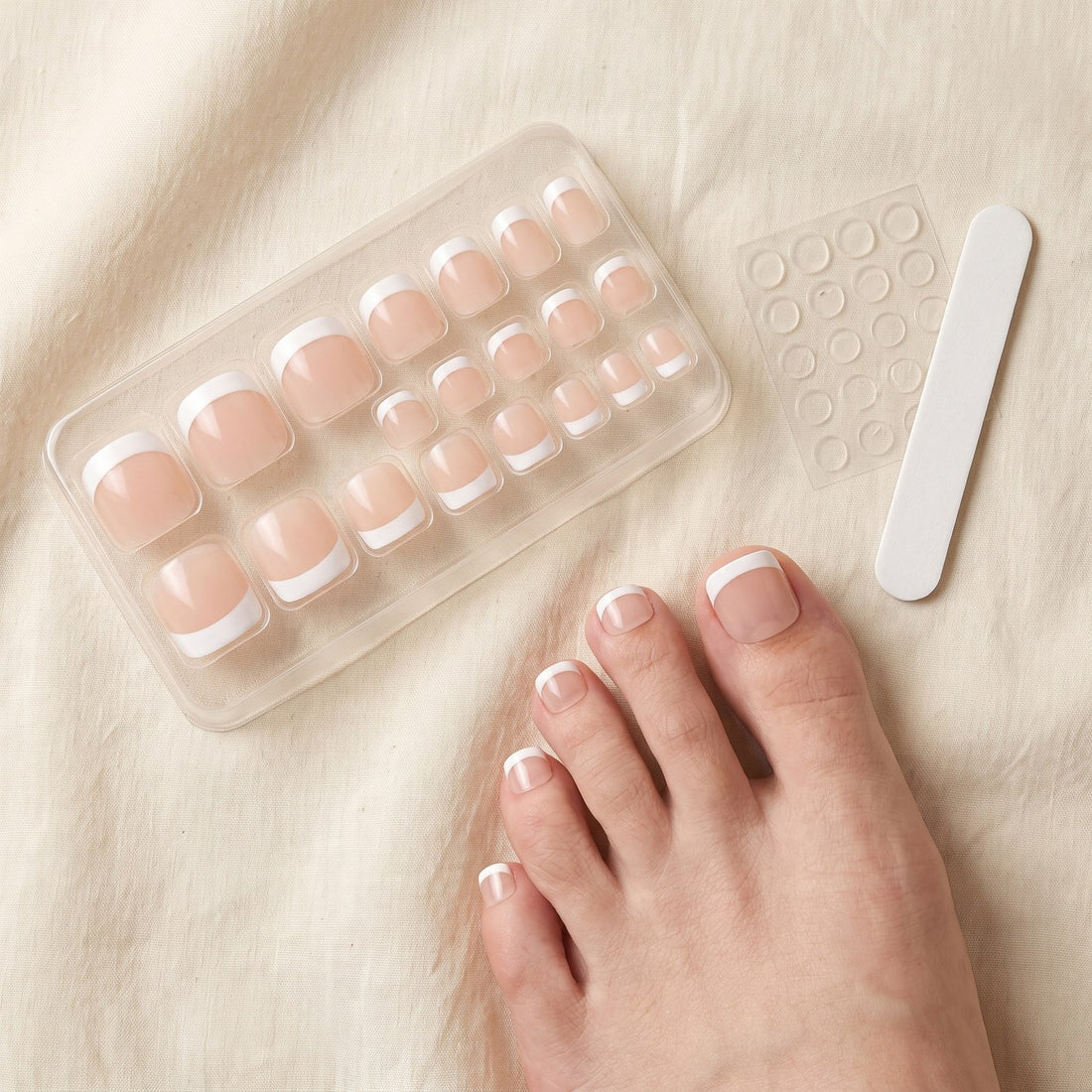 What arrives: the tray of graded French toenails, the jelly glue tabs and the nail file