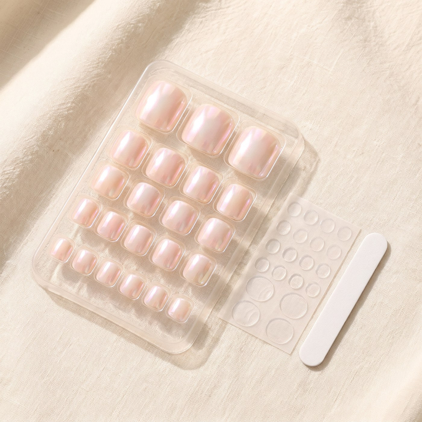 What arrives: the tray of graded toenails, the sheet of jelly glue tabs and the nail file