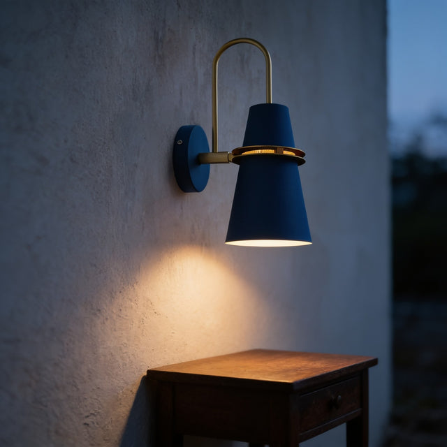 Deep blue horn wall sconce on a brass arm above a wooden side table