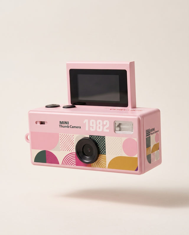 Mini Handheld Flip Camera in pink with its screen flipped up, shown against a cream background